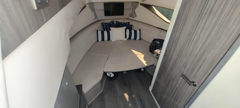 Slide: The Image of 2021 Sea Ray Sundancer 320 cabin interior with cozy seating and decorative pillows. - 14