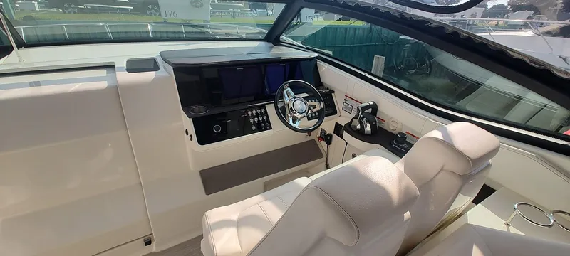 Slide: The Image of 2021 Sea Ray Sundancer 320 cockpit with modern controls and plush seating. - 8