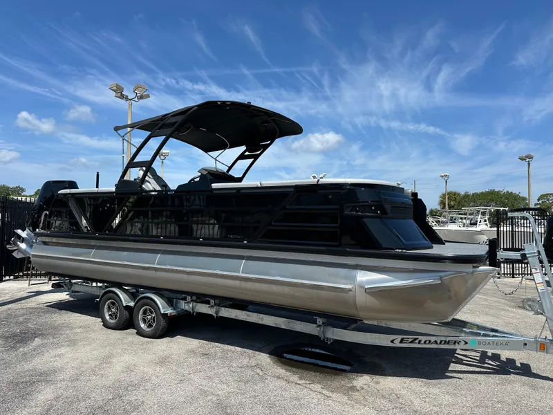 Slide: The Image of 2025 Veranda VX 25 RC pontoon boat on trailer under clear blue sky. - 1