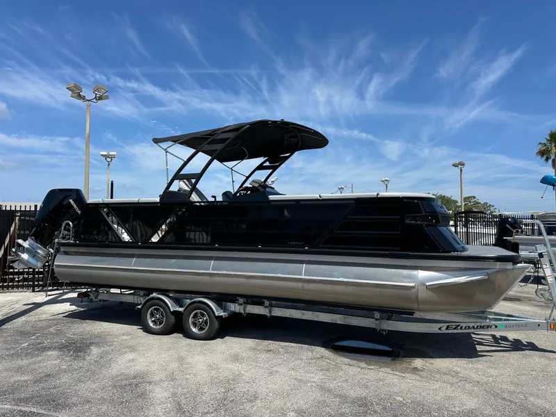 Slide: The Image of 2025 Veranda VX 25 RC pontoon boat on trailer under clear blue sky. - 2