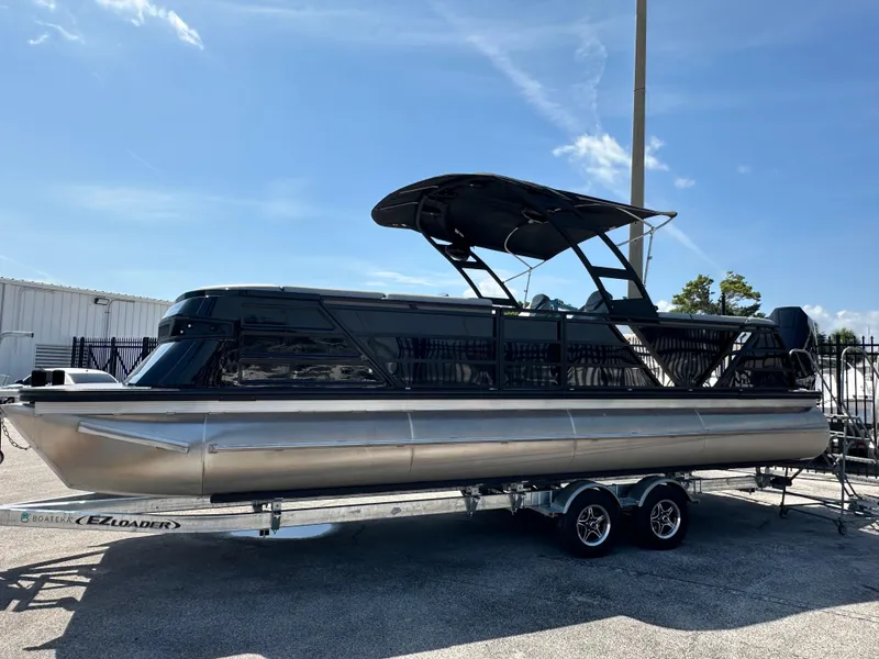 Slide: The Image of 2025 Veranda VX 25 RC pontoon boat on trailer under clear sky. - 7