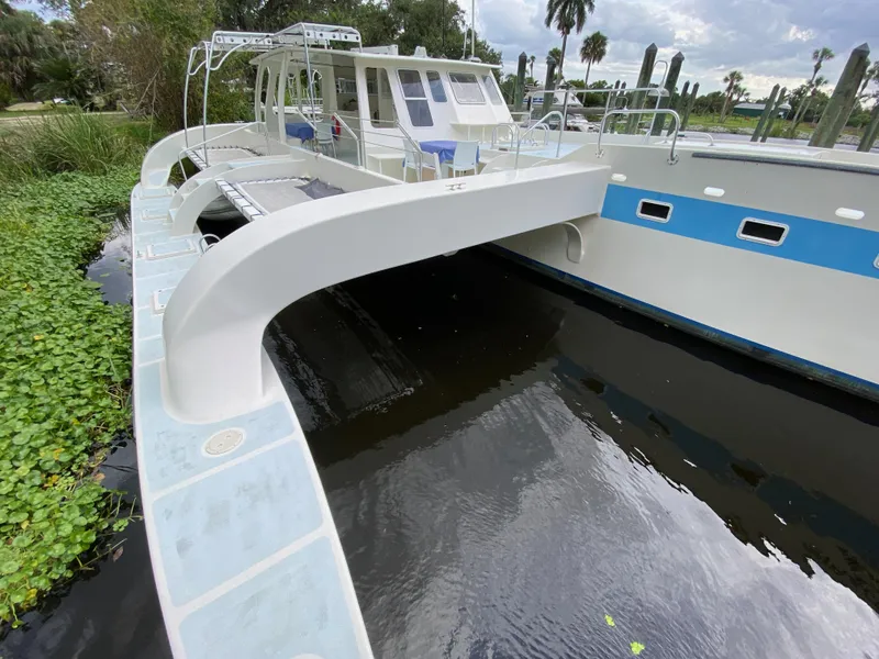The Image of Custom 62 boat from 1996 docked near lush greenery and calm water. - 0