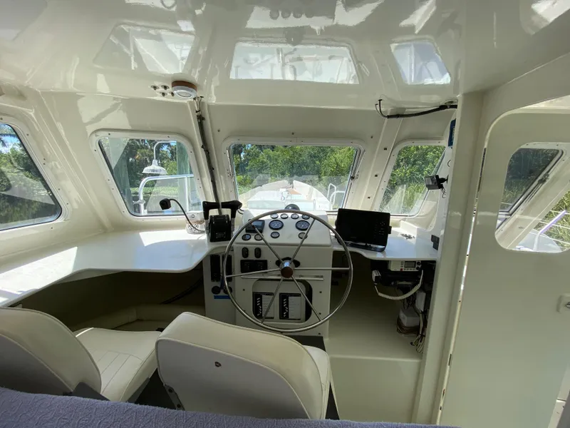 Slide: The Image of Interior view of a 1996 Custom 62 boat cockpit with steering wheel and navigation equipment. - 15