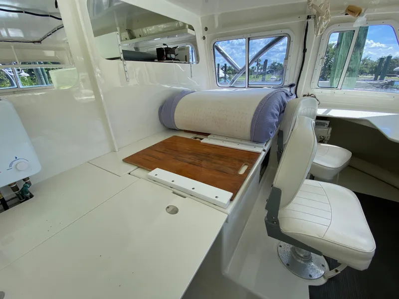 Slide: The Image of Interior of a 1996 Custom 62 boat with seating and wooden table. - 16