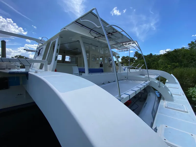 Slide: The Image of Custom 62 catamaran from 1996, docked under a clear blue sky. - 22