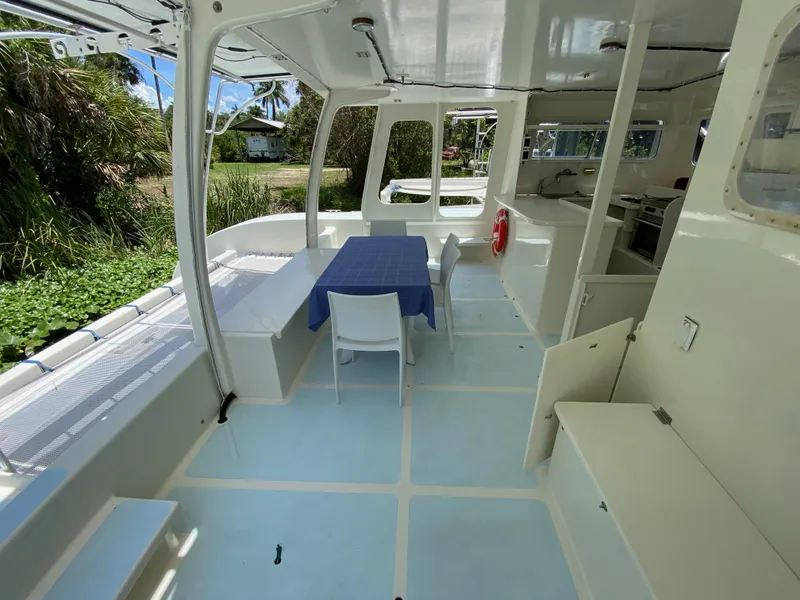 Slide: The Image of Spacious boat interior with table, chairs, and kitchen area, Custom model 62, 1996. - 23