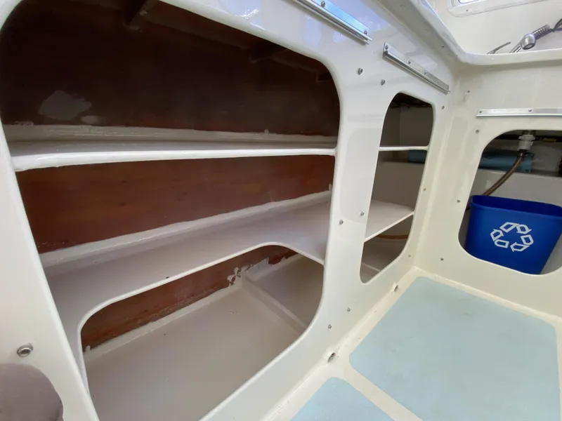 Slide: The Image of Interior shelves of a 1996 Custom model 62 boat with a recycling bin. - 26