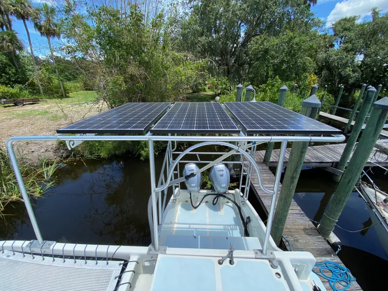 Slide: The Image of Solar panels on a custom 1996 boat docked near lush greenery and water. - 36