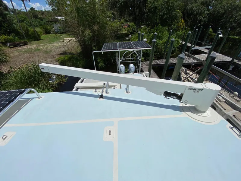 Slide: The Image of Boat crane labeled "Quick Lift" on a Custom 62, 1996 model, with scenic waterway background. - 39