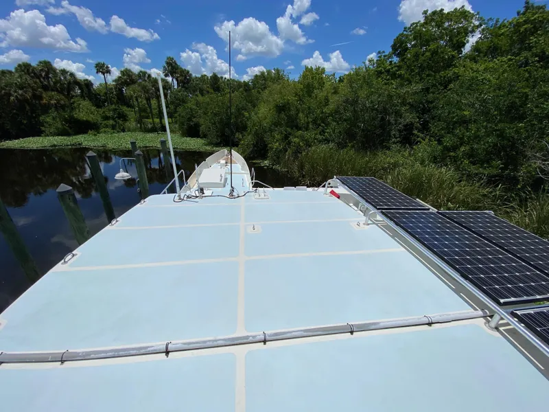 Slide: The Image of Custom 62 boat from 1996 on a serene river with lush greenery. - 41