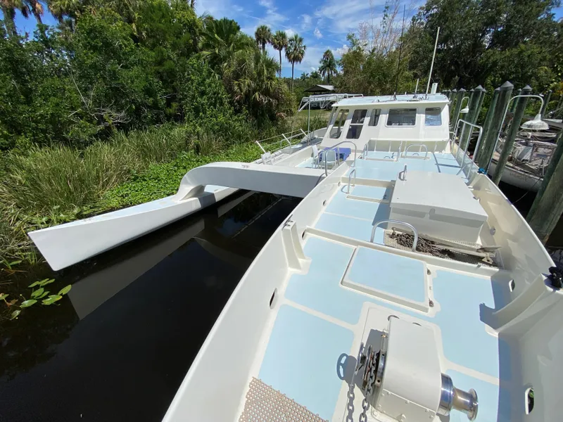 Slide: The Image of Bow of a 1996 Custom 62 boat with anchor winch and lush greenery. - 5