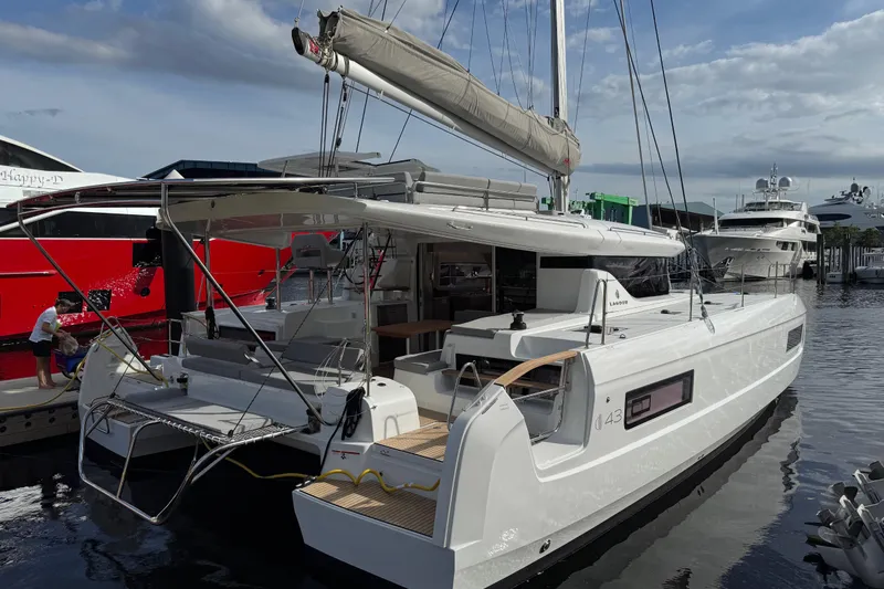 The Image of Modern 2026 Lagoon 43 yacht docked at marina, showcasing sleek design and spacious deck. - 0