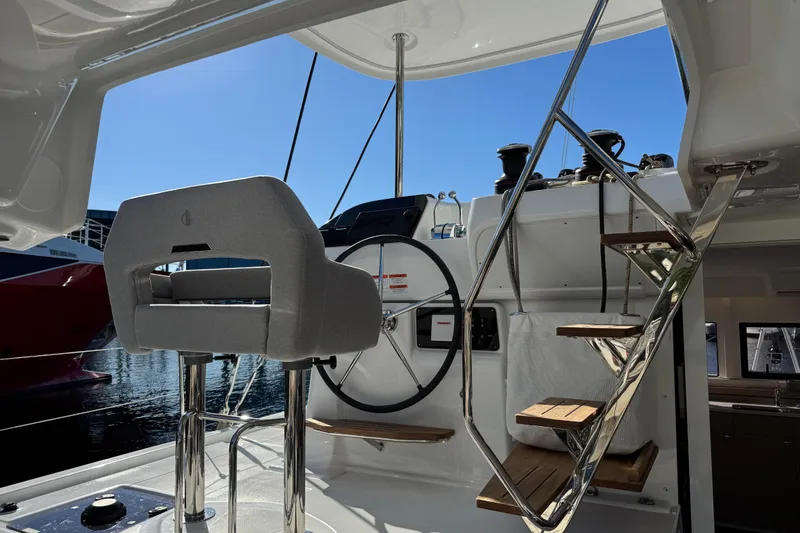 Slide: The Image of Helm station of 2026 Lagoon 43 yacht with steering wheel and steps. - 24