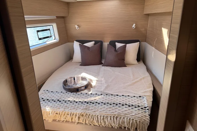 Slide: The Image of Luxurious cabin interior of 2026 Lagoon 43 yacht with cozy bed and window view. - 30