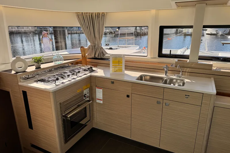 Slide: The Image of Modern kitchen interior of 2026 Lagoon 43 yacht with stove, sink, and waterfront view. - 43