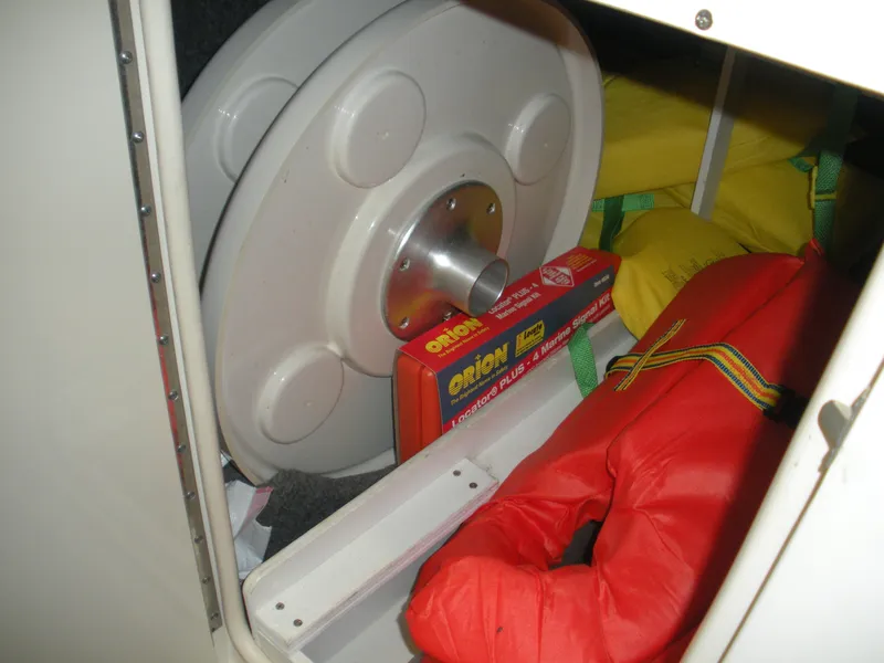 Slide: The Image of Storage compartment of 2007 Sea Ray 220 Sundeck with life jackets and marine signal kit. - 18