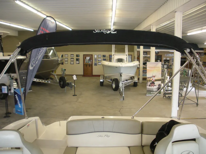 Slide: The Image of 2007 Sea Ray 220 Sundeck displayed in a showroom with other boats. - 21