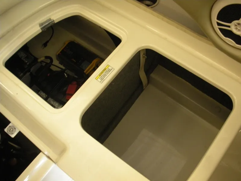 Slide: The Image of Storage compartment of a 2007 Sea Ray 220 Sundeck boat, showing battery and speaker. - 26