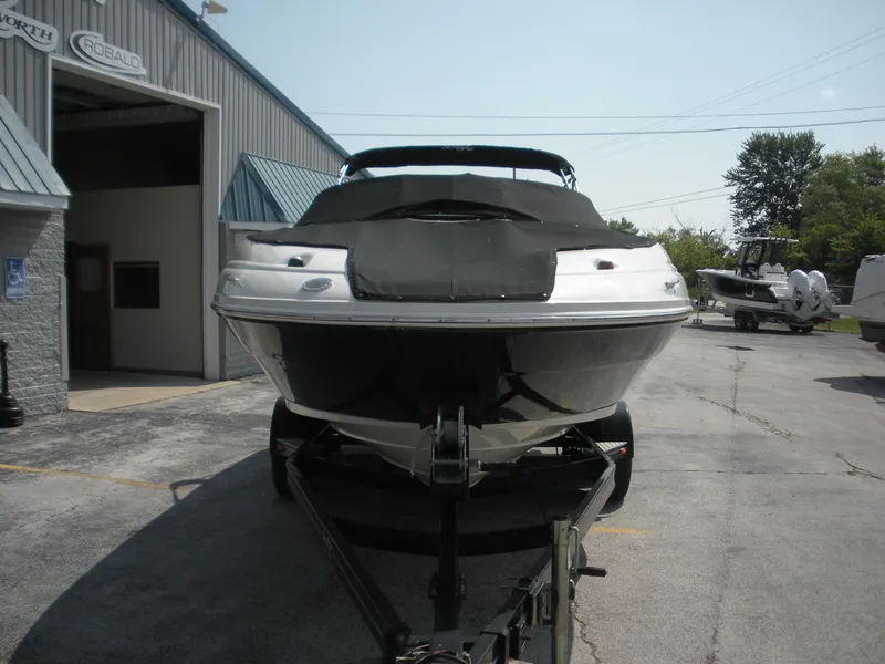 Slide: The Image of 2007 Sea Ray 220 Sundeck boat on trailer outside a marine dealership. - 4