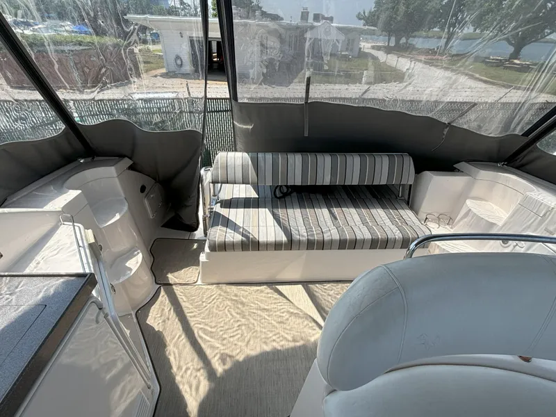 Slide: The Image of 2006 Regal Commodore 3560 IO boat interior with striped seating and clear canopy. - 12