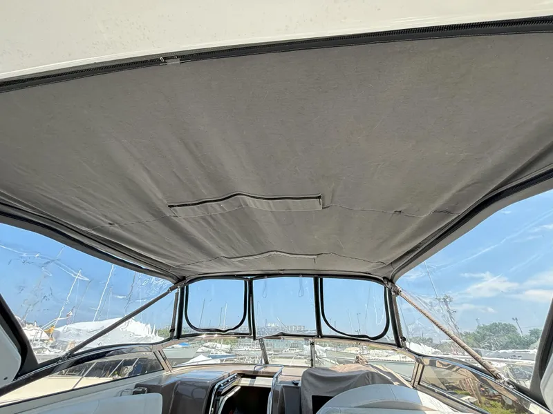 Slide: The Image of 2006 Regal Commodore 3560 IO boat interior with canopy and clear sky view. - 15