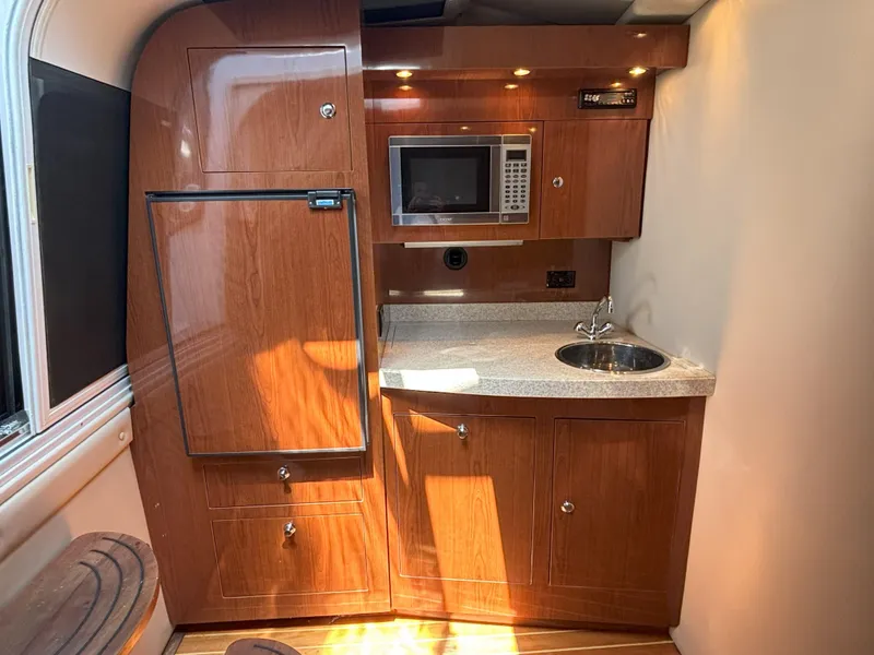 Slide: The Image of 2006 Regal Commodore 3560 IO yacht kitchen with wood cabinetry, microwave, and sink. - 39