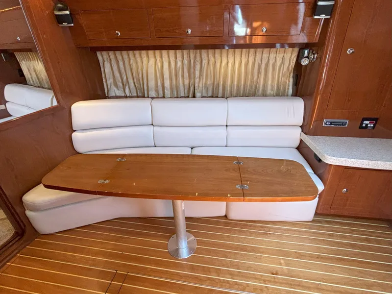 Slide: The Image of Interior of 2006 Regal Commodore 3560 IO yacht with white seating and wooden table. - 41