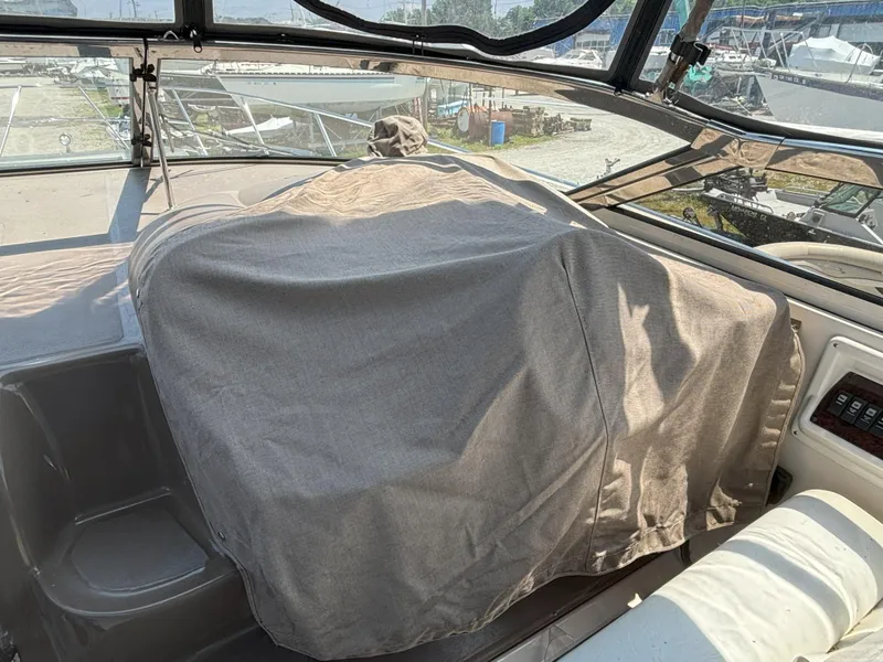 Slide: The Image of 2006 Regal Commodore 3560 IO boat interior with covered dashboard and marina view. - 8