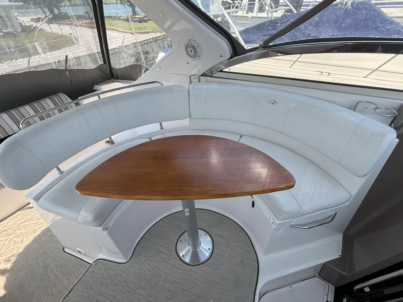 Slide: The Image of 2006 Regal Commodore 3560 IO boat interior with curved seating and wooden table. - 9