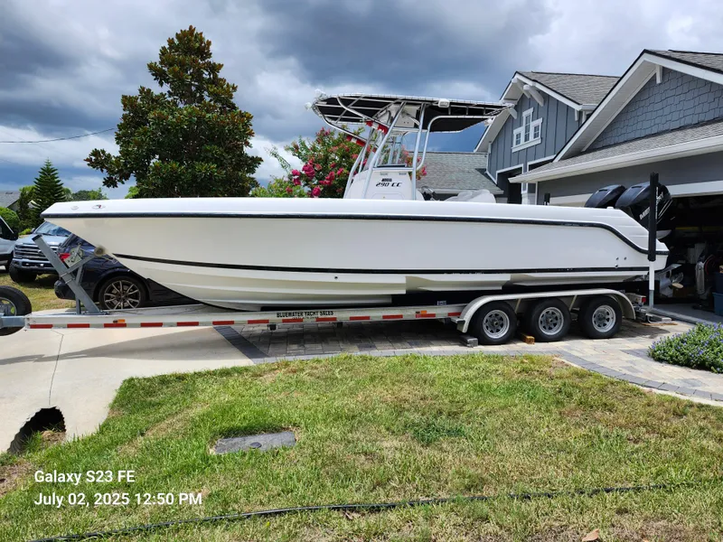 The Image of 2010 Donzi 29ZF boat on trailer in residential driveway, cloudy sky background. - 0