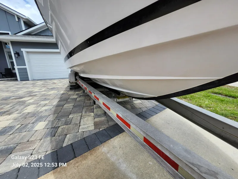 Slide: The Image of 2010 Donzi 29ZF boat on trailer in driveway, next to a black car. - 11