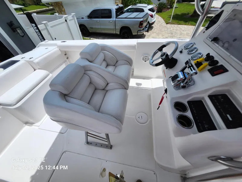 Slide: The Image of 2010 Donzi 29ZF boat interior with dual Mercury engines, white seating, and storage compartments. - 14