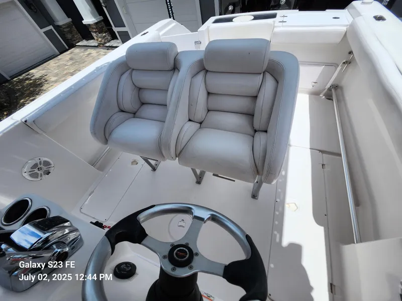Slide: The Image of Interior of a 2010 Donzi 29ZF boat featuring a white captain's seat and control panel. - 15
