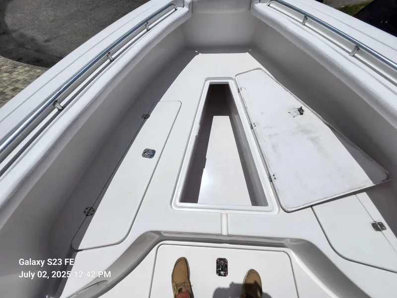 Slide: The Image of 2010 Donzi 29ZF boat interior with white deck and storage compartments. - 18