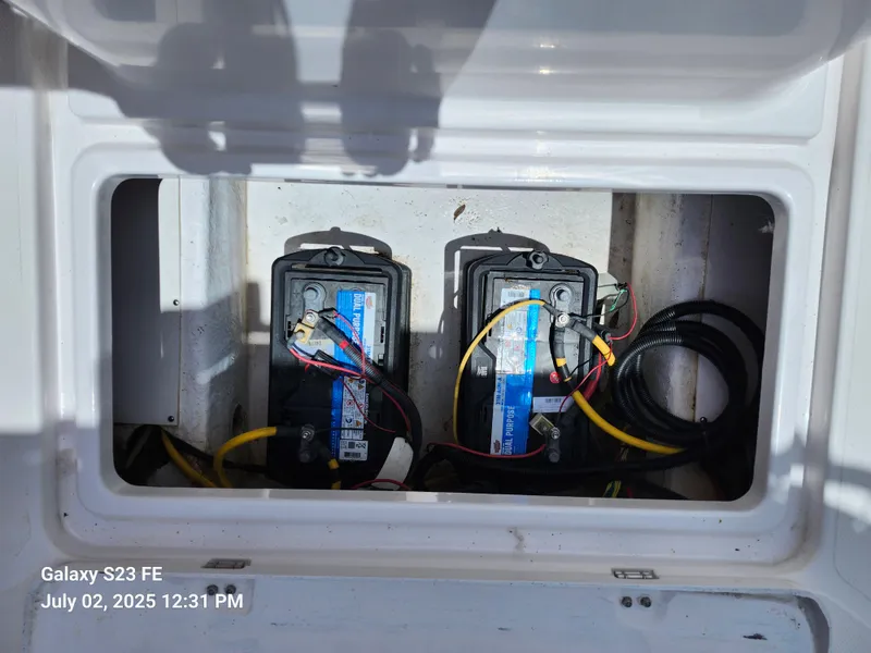 Slide: The Image of 2010 Donzi 29ZF boat deck with open storage compartment, parked near a white truck. - 21