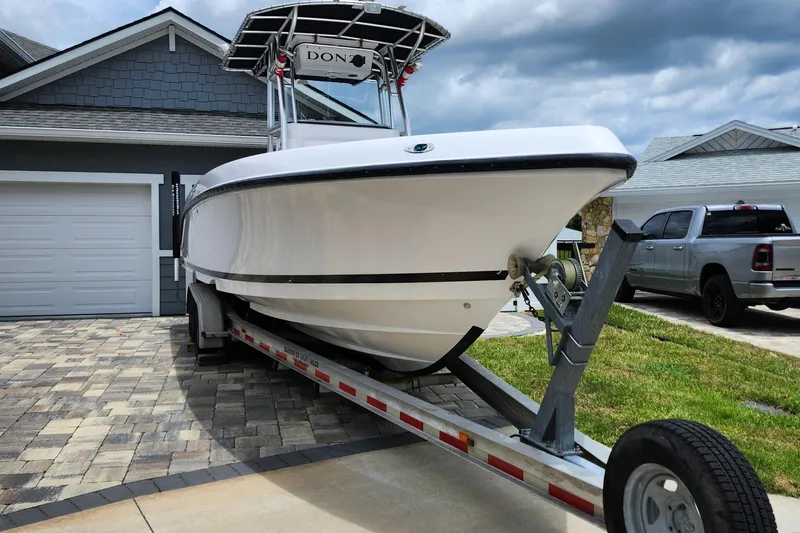 Slide: The Image of 2010 Donzi 29ZF boat on trailer in driveway, cloudy sky background. - 3