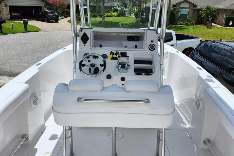 Slide: The Image of 2010 Donzi 29ZF boat cockpit with steering wheel, controls, and seating in a residential driveway. - 7