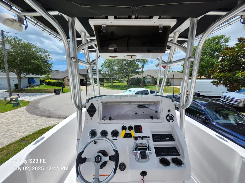 Slide: The Image of 2010 Donzi 29ZF boat cockpit with steering wheel and controls, parked in a residential area. - 8