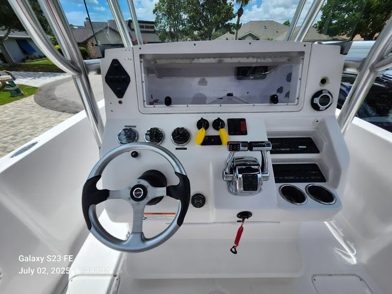 Slide: The Image of 2010 Donzi 29ZF boat dashboard with steering wheel and controls, parked in a residential area. - 9
