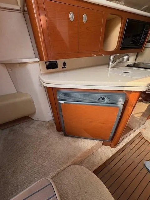 Slide: The Image of Interior of 2008 Sea Ray 270 Amberjack boat with kitchenette and wood cabinetry. - 16