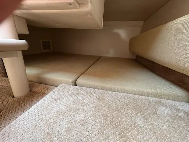 Slide: The Image of 2008 Sea Ray 270 Amberjack cabin interior with beige cushions and carpeted flooring. - 17