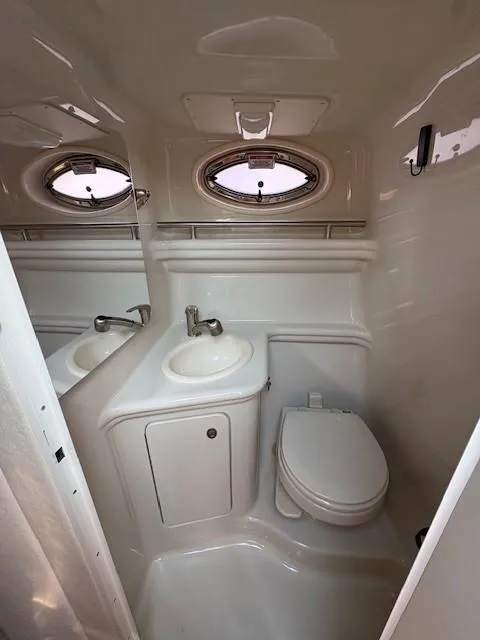 Slide: The Image of 2008 Sea Ray 270 Amberjack boat bathroom with sink, toilet, and porthole window. - 18