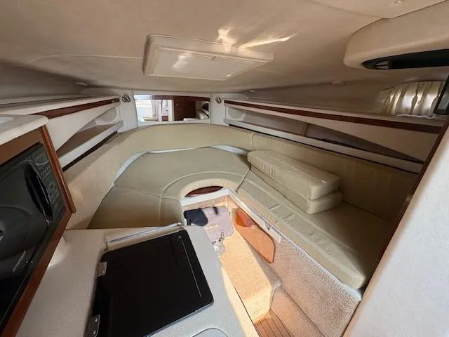 Slide: The Image of 2008 Sea Ray 270 Amberjack cabin interior with beige seating and compact design. - 19