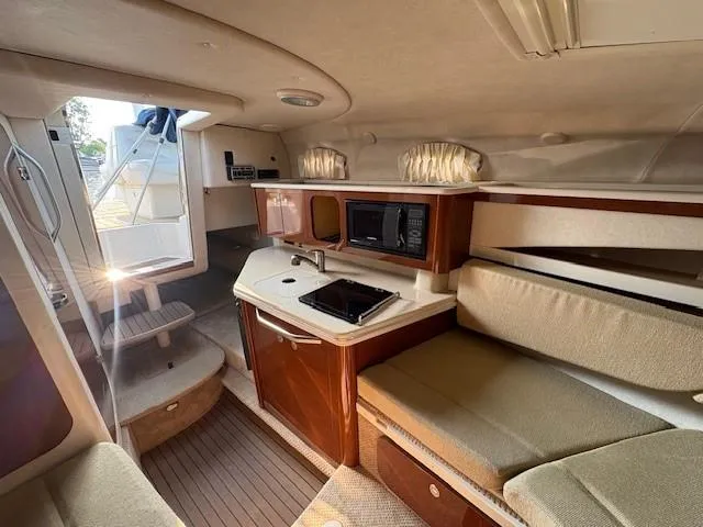 Slide: The Image of Interior of 2008 Sea Ray 270 Amberjack boat with kitchenette and seating area. - 21