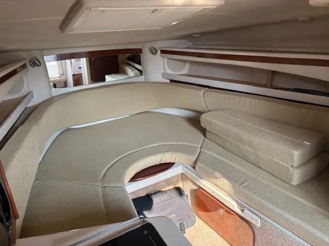 Slide: The Image of 2008 Sea Ray 270 Amberjack cabin interior with beige seating and wood accents. - 22