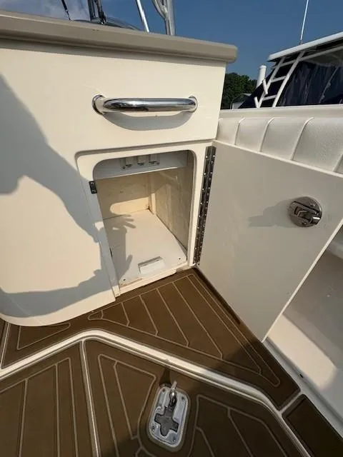 Slide: The Image of Open storage compartment on 2008 Sea Ray 270 Amberjack boat with brown flooring. - 5