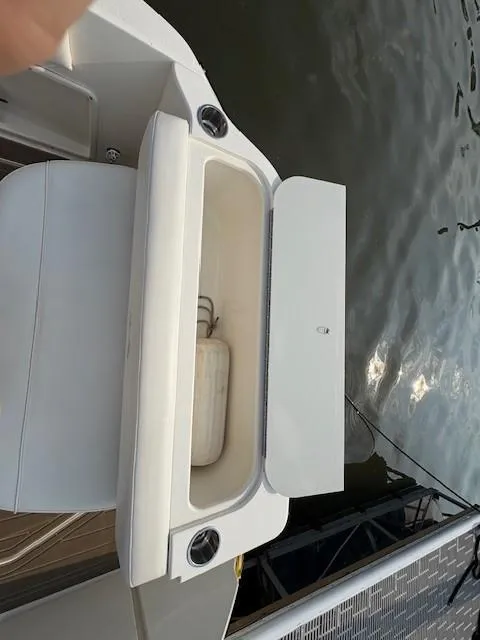 Slide: The Image of Open storage compartment on 2008 Sea Ray 270 Amberjack boat by the water. - 6