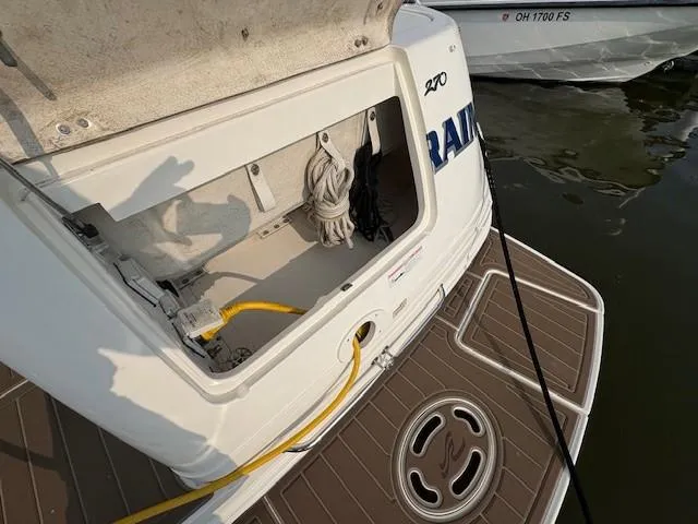 Slide: The Image of 2008 Sea Ray 270 Amberjack boat with open storage compartment and docked at marina. - 8
