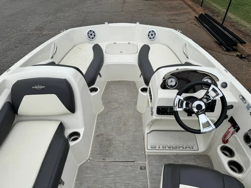 Slide: The Image of 2019 Stingray 182 SC boat interior with steering wheel, seating, and cup holders. - 8