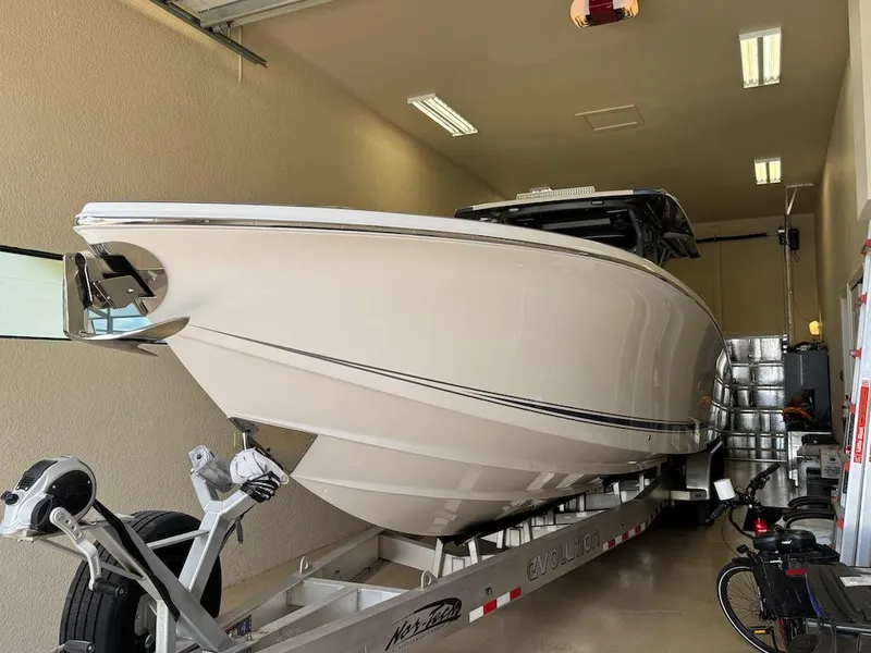 The Image of 2024 Nor-Tech 390 Sport Center Console boat on trailer in garage. - 1